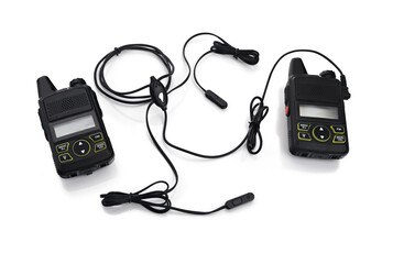 Two black walkie-talkies with earpieces and microphones, showcasing communication devices for outdoor activities, emergency services, and teamwork in various environments