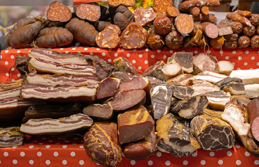 Homemade dry cured pork meat bacon and sausages sold outside on local market