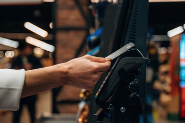 Hand of a customer is using a credit card at a payment terminal in a modern retail environment, showcasing the convenience of contactless transactions