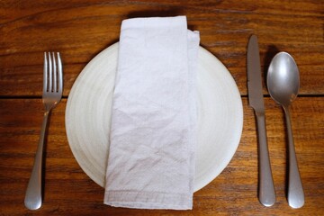 BANGKOK, THAILAND – JUNE 15, 2025: A high-angle view of a minimalist place setting with a white...
