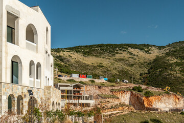 Unfertiges Hotelgebäude vor felsigem Hang in Küstenregion, Jala, Qark Vlora, Albanien