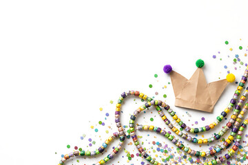 Mardi Gras celebration with colorful beads and paper crown on white background