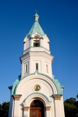 Fototapeta premium HAKODATE, JAPAN – JULY 24, 2025: The bell tower of the historic Hakodate Orthodox Church, featuring its signature turquoise roofs and Russian architecture in the Motomachi district of Hokkaido.