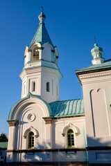 Obraz premium HAKODATE, JAPAN – JULY 24, 2025: The distinctive turquoise-green domes and white facade of the Hakodate Orthodox Church, a Russian-style landmark in the historic Motomachi district of Hokkaido.