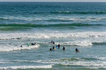 surfers facing waves at Voelklip Beach cove, Hermanus, South Africa