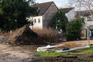 A pile of earth and rolls of white film at a construction site