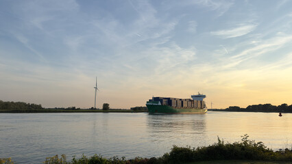 Containerschiff auf ruhigem Fluss bei Sonnenuntergang