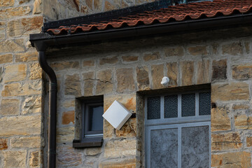 Building with stone wall and unique window design in afternoon light