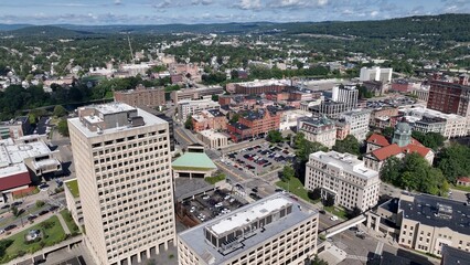 Obraz premium Binghamton, NY downtown city skyline with office buildings, historic architecture, public parks and river flowing through town on Summer sunny warm day