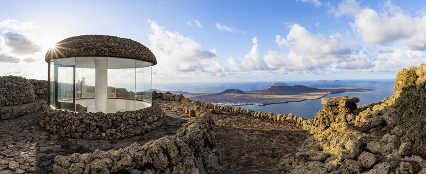 Stairway and viewing platform at the Mirador del R&iacute;o viewpoint, in the evening light with sun stars, designed by artist C&eacute;sar Manrique, view of the island of La Graciosa, Lanzarote, Canary Islands, Spain
