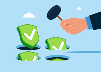 Hand holding hammer hitting the green shields check marks symbols in a mole hole. Playing hamster game. Business constraints or stagnant, prohibition or difficulty prevent from improvement or success.