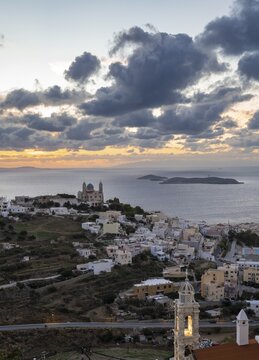 View from Ano Syros to the houses of Ermoupoli with the Anastasi Church or Church of the Resurrection, town view with islands and sea, dramatic cloudy sky at sunrise, Ano Syros, Syros, Cyclades, Greecev