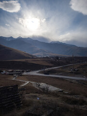 Majestic mountain landscape under dramatic clouds with sunlight breaking through, showcasing a...