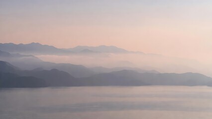 Fototapeta premium Serene mountain landscape with misty layers over calm water at dawn