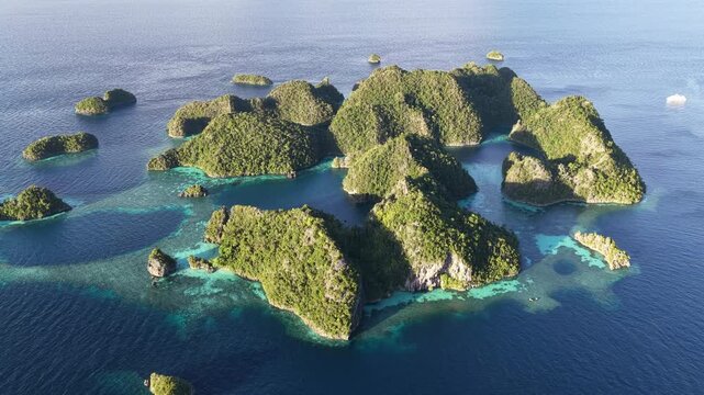 The scenic islands of Wyil rise from the seascape near Misool, Indonesia. This region harbors spectacular marine biological diversity and is a popular destination for divers and snorkelers.