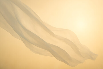 Flowing white fabric gently illuminated by soft golden light