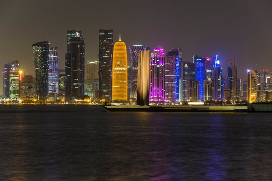 Colorful light of capital West Bay skyline at night with Steel Obelisk and West Mound-Skyline View Point seen from museum of islamic art with big text space. Doha, Qatar