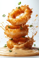 floating calamari rings with tartar sauce splash, isolated on white background