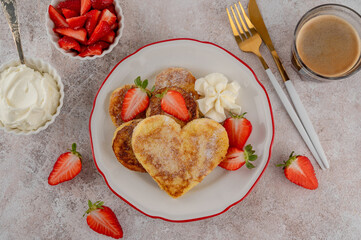 Valentine's Day breakfast: heart-shaped French toast with strawberries and whipped cream on a plate. Romantic brunch dessert. Top view.?