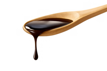 Dark liquid sauce dripping from a wooden spoon, adding flavor and richness to food, transparent background