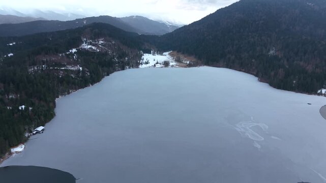 Drohnenaufnahme vom Barmsee nahe Mittenwald in Bayern. Winterlandschaft mit Eis, Schnee und alpiner Natur aus der Luft. Aerial view of winter landscape at Barmsee in Bavaria. Karwendel mountains.