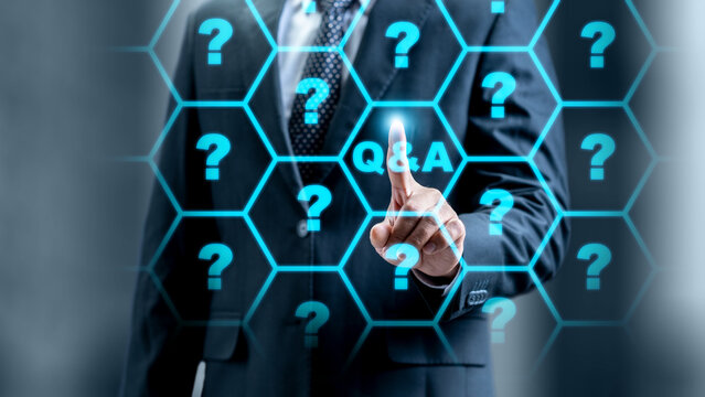 Businessman in a suit touching a digital screen with a Q and A button surrounded by question marks. Concept for questions and answers, online support, and information - Powered by Adobe