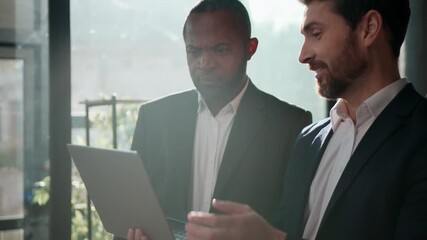 Two diverse men multiracial businessmen business team online presentation with laptop in sunny office teamwork working Caucasian businessman presenting digital data African American leader listening - Powered by Adobe