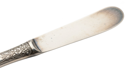 Ornate silver butter knife with floral engraving on handle against black background image