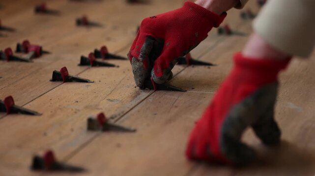 Man fixing Tile Leveling System Components. Man tiling a floor. 4K
