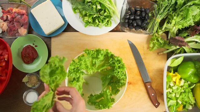 Top view of lettuce leaves serving a bowl torn from the stem and arran
