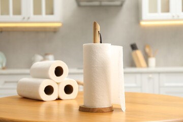 Naklejka premium Rolls of paper towels on wooden table in kitchen
