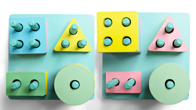 Top view of a shape sorting toy made of painted wood on a light blue background. The toy features geometric shapes like squares, triangles, rectangles, and circles for a child to sort and learn