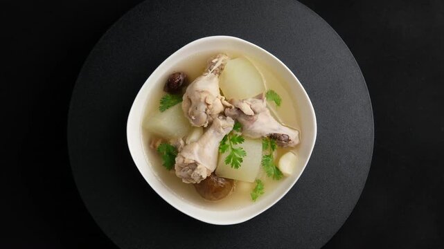 Winter Melon with Chicken wings (drumettes) and preserved lime soup in white bowl.Thai food.Top view.