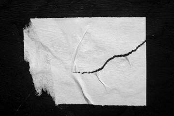 Old torn city poster on black background close-up