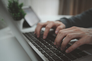 Hand typing on laptop keyboard at home office workspace. Freelancer working online, using computer for business, education, coding, and digital marketing concept. Representing work productivity, 