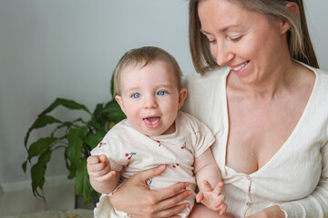 Mom and a baby playing and laughing together. Copy space, background.