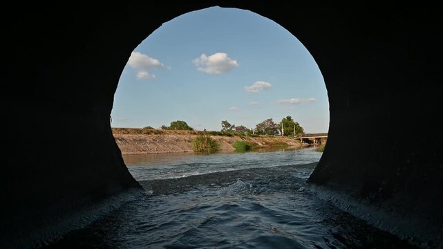 Water flows out of the drainage pipes into the community canal