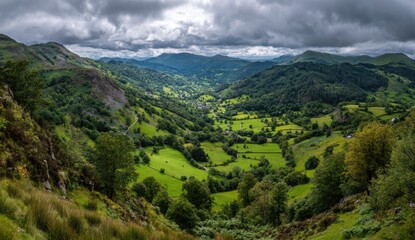 Fototapeta premium Lush green valley scene framed by hills beneath a moody, dramatic sky