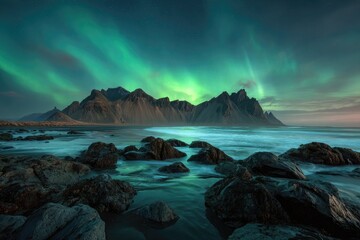 Majestic mountain range at ocean's edge under vibrant aurora borealis