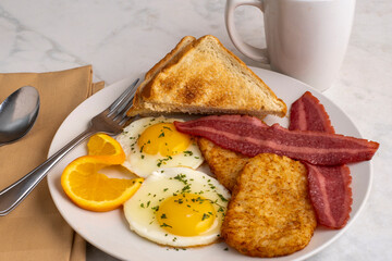 fried eggs  with  hash browns and turkey bacon