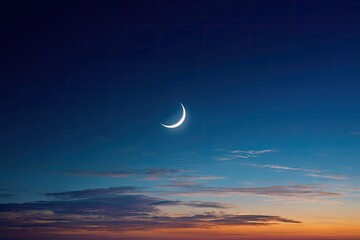 Crescent moon shines brightly in the twilight sky, with colorful sunset clouds below
