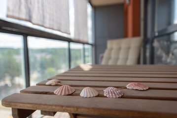 Decorative Seashells on Wooden Tabletop Overlooking Scenic Balcony View