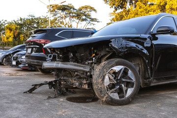 Damaged Black Car After Traffic Accident With Broken Front and Exposed Mechanical Parts