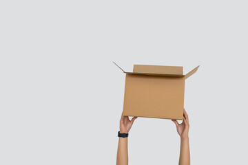 Hand Holding Open Cardboard Box Isolated on Light Gray Background with Copy Space