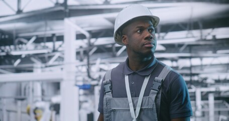 Industrial Male Engineer Walking Through Modern Factory Floor and Inspecting Automated Production...