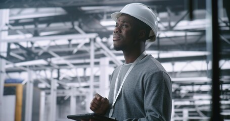 Dedicated Technician Concerned Expression While Holding Tablet, Suggesting Troubleshooting Industrial Alert or Issue in Large, Modern Machinery of Plant. Problem solving and Operational Intensity.