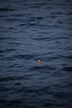 A small red fishing bobber in the water of the Pamlico Sound