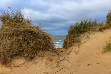 Dramatische K&uuml;stenlandschaft mit Sandd&uuml;nen und wechselhaftem Himmel