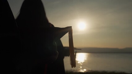 Close-up silhouette of a graduation cap against a sunset sky with water reflection, symbolizing academic success, reflection, and a new chapter.