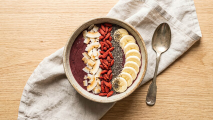 Overhead Flat Lay Of Vibrant Acai Smoothie Bowl Topped With Dried Antioxidant Goji Berries Coconut Flakes Chia Seeds And Sliced Bananas